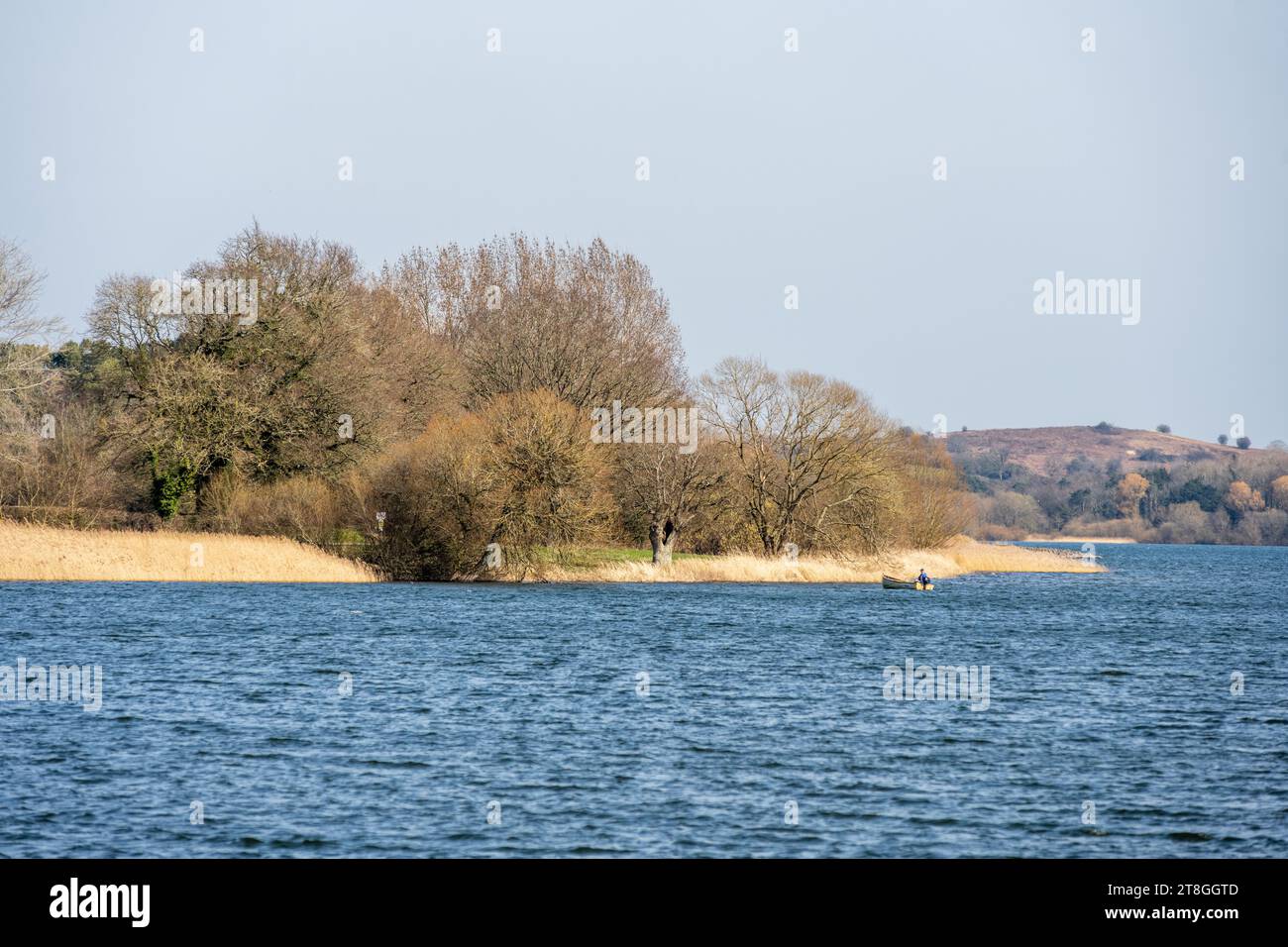 Ein Mann fischt von einem kleinen Boot auf dem Chew Valley Lake Reservoir in North Somerset, England. Stockfoto