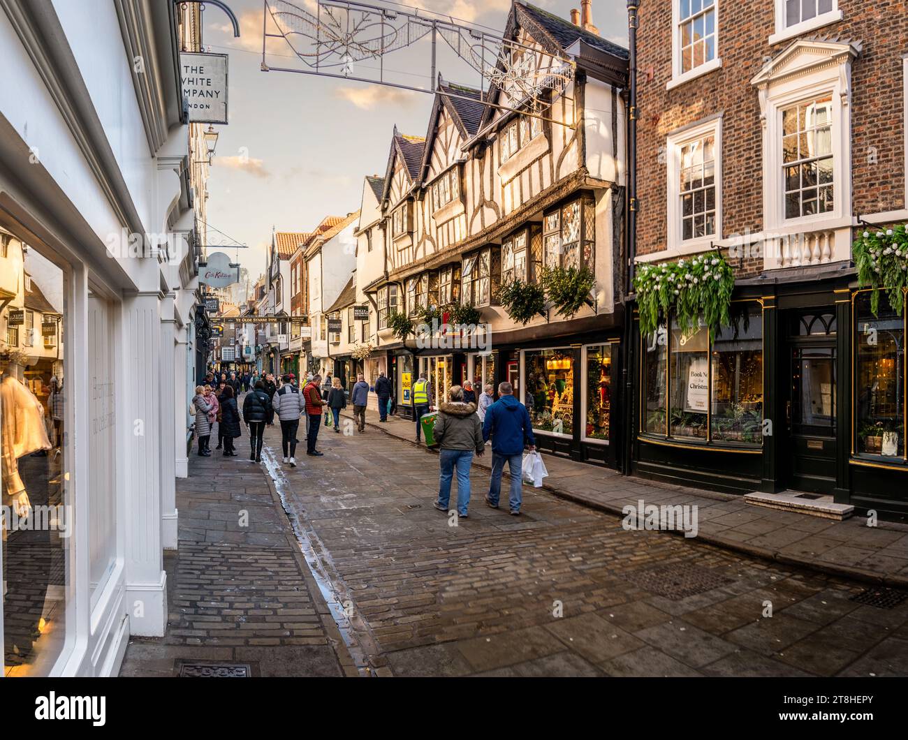 STONEGATE, YORK, GROSSBRITANNIEN - 17. NOVEMBER 2023. Shopper und Menschenmassen laufen durch die Einkaufsstraße Stonegate mit Einzelhandelsgeschäften wie dem Kat Stockfoto