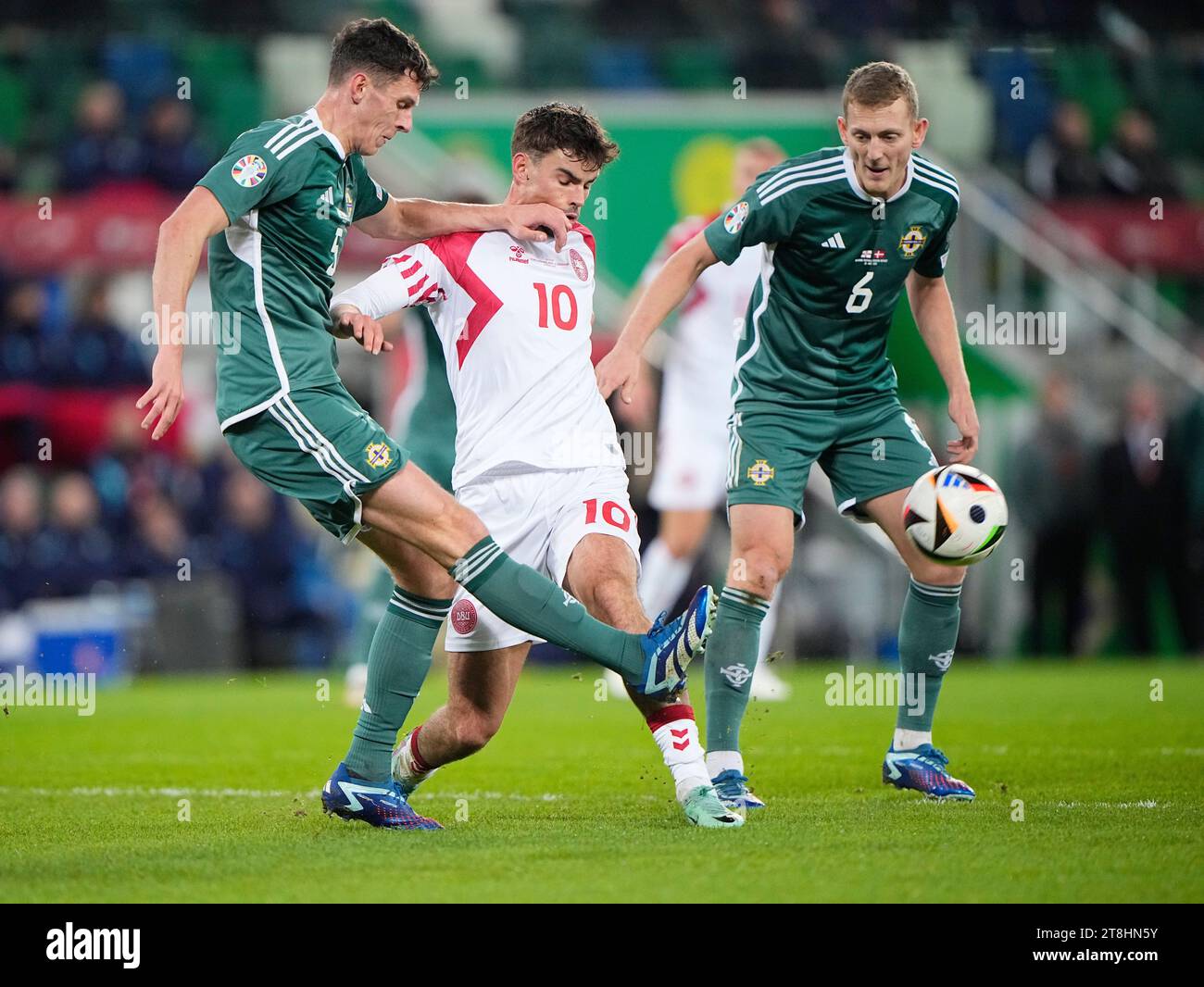 Eoin Toal und George Saville (6) aus Nordirland und Matt O'Riley, Dänemark (10) wetteifern um den Ball beim Gruppenspiel der UEFA Euro 2024 in der zweiten Runde der Gruppe H zwischen Nordirland und Dänemark am Montag, den 20. November 2023 in Belfast. Stockfoto