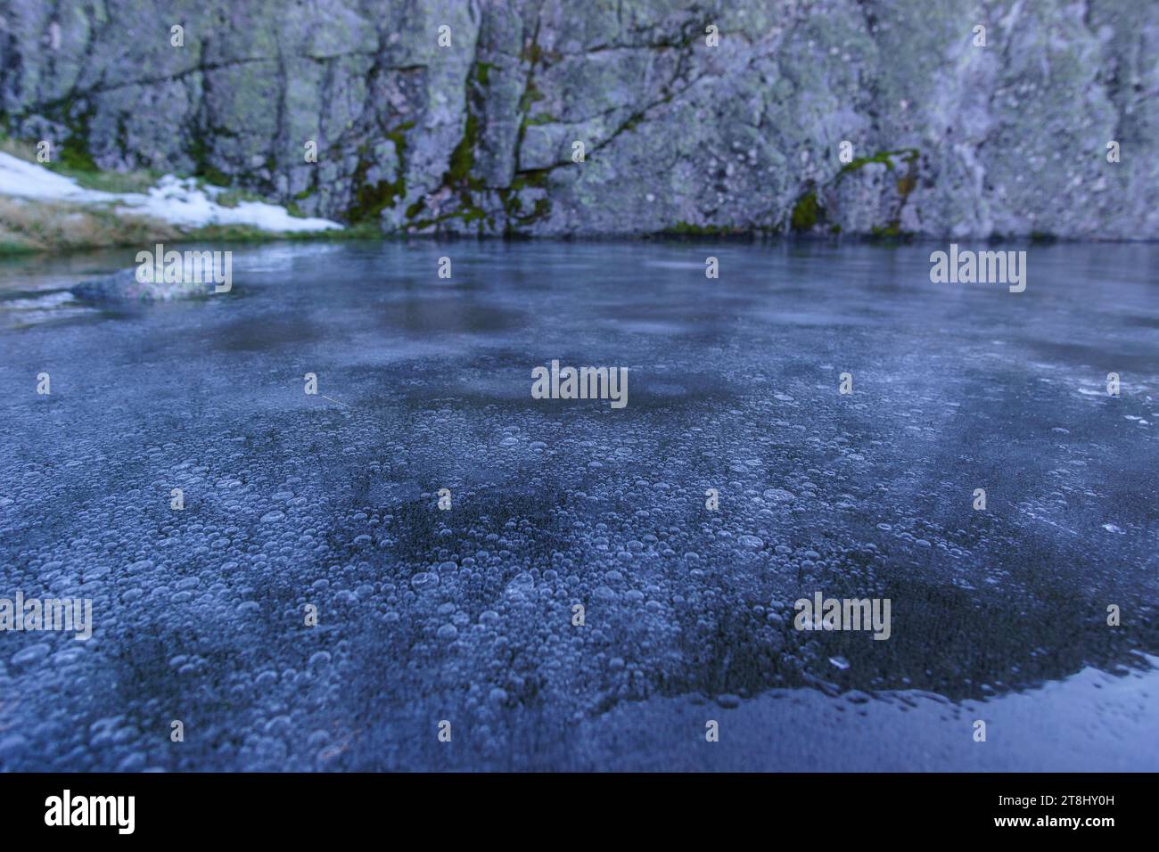 Abstrakter Hintergrund von Luftblasen unter Eisschicht im Klarwassersee Stockfoto