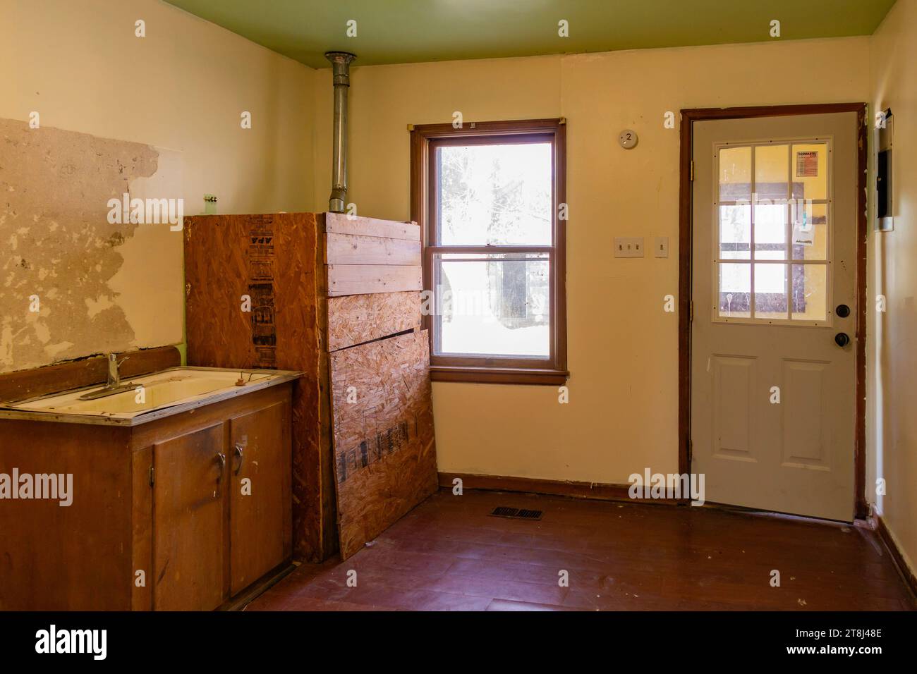 Schäbiger, heruntergekommener Raum in einem alten Bauernhaus zum Verkauf, der renoviert werden muss. West-Kansas, USA. Stockfoto