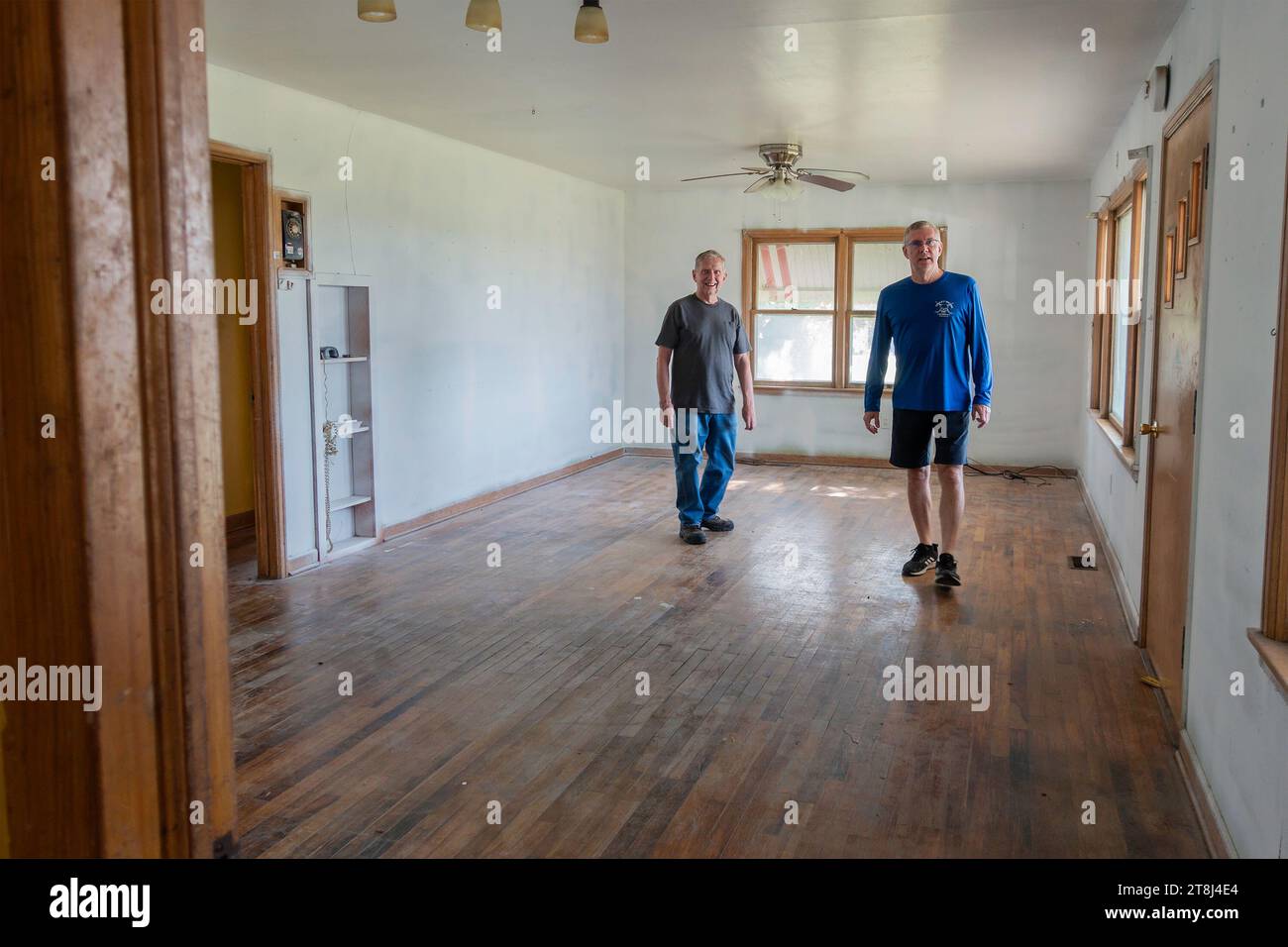 Senior man Besitzer eines alten, veralteten und schäbigen Bauernhauses zeigt es einem jüngeren Mann, einem potenziellen Käufer. West-Kansas, USA. Stockfoto