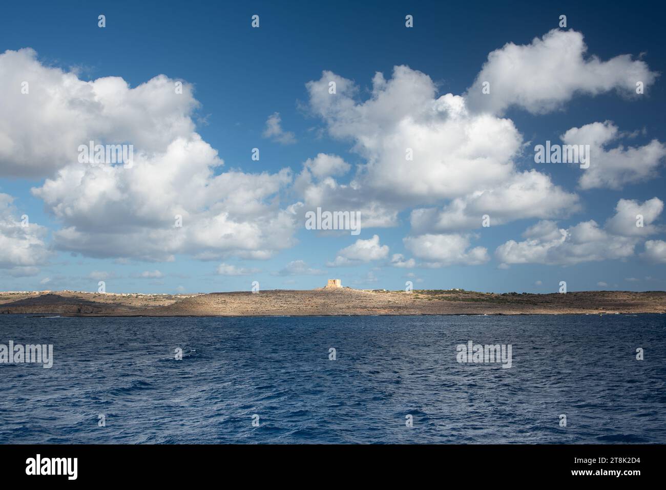 Blick auf die Insel Gozo in Malta am Horizont. Vor der kleineren Insel Comino. Es gibt viele weiße Wolken am blauen Himmel, die sich in t spiegeln Stockfoto