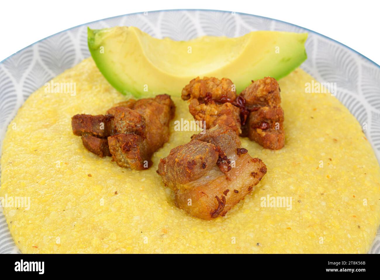 Gekochtes Maismehl in kubanischer Küche. Avocado und gebratenes Schweinefleisch Stockfoto