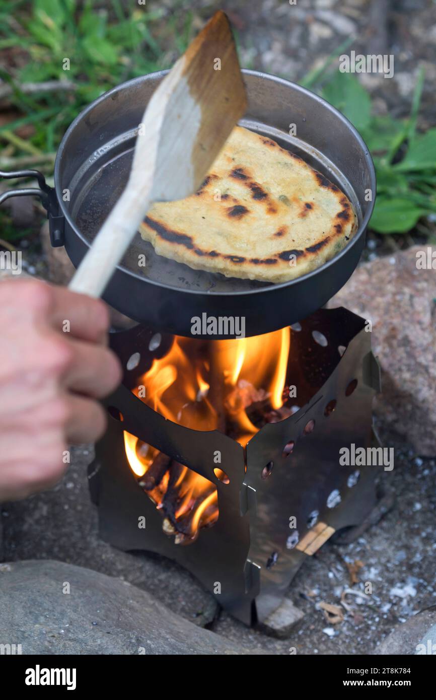 Bannockherstellung, wird auf offenem Feuer gebacken, Brotteig wird gebildet und in einer Pfanne auf einem Campingkocher gebacken, Serienbild 5/5 Stockfoto