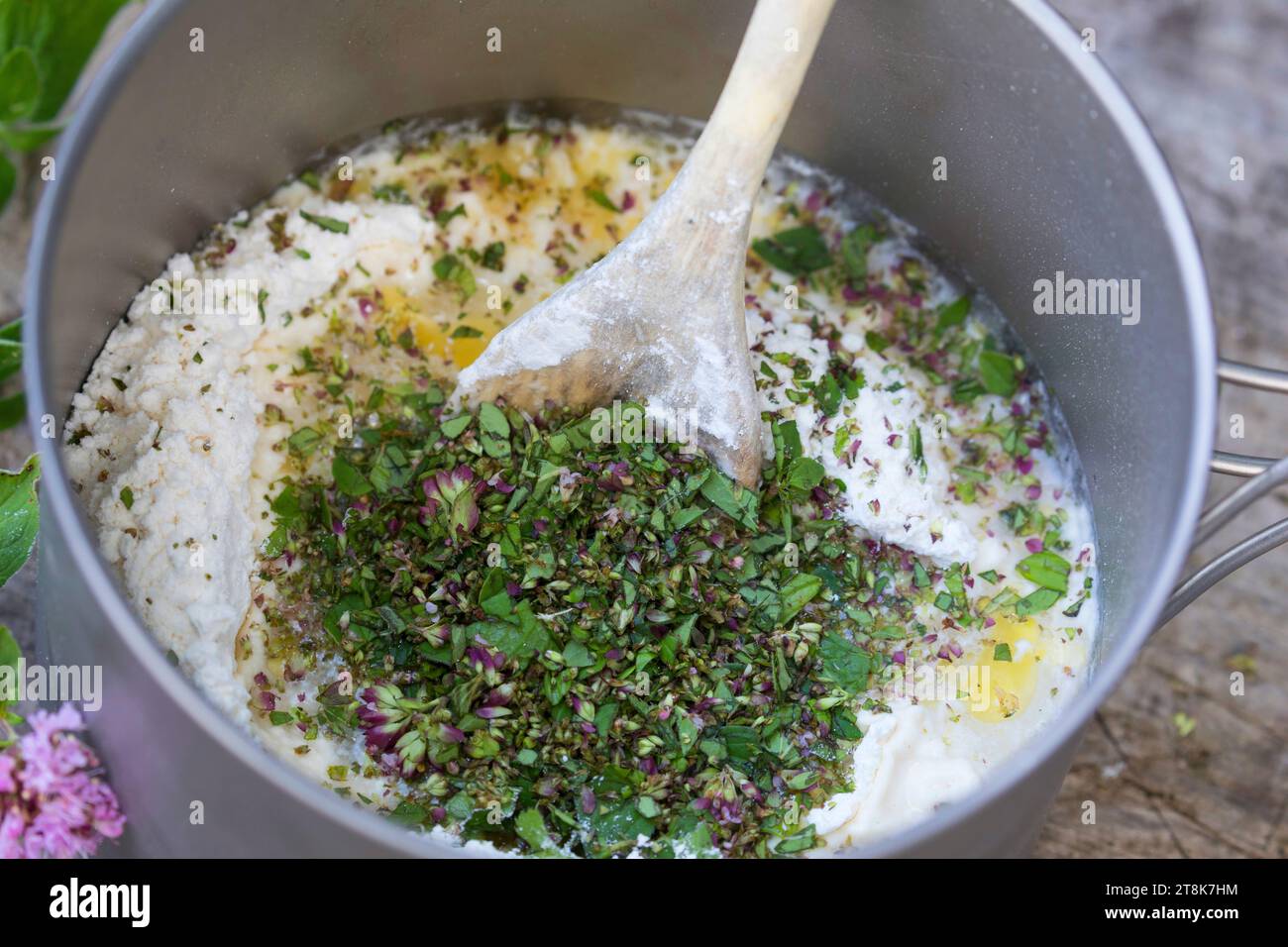 Bannock machen, wird auf offenem Feuer gebacken, gehackte Kräuter werden hinzugefügt, Serienbild 4/5 Stockfoto