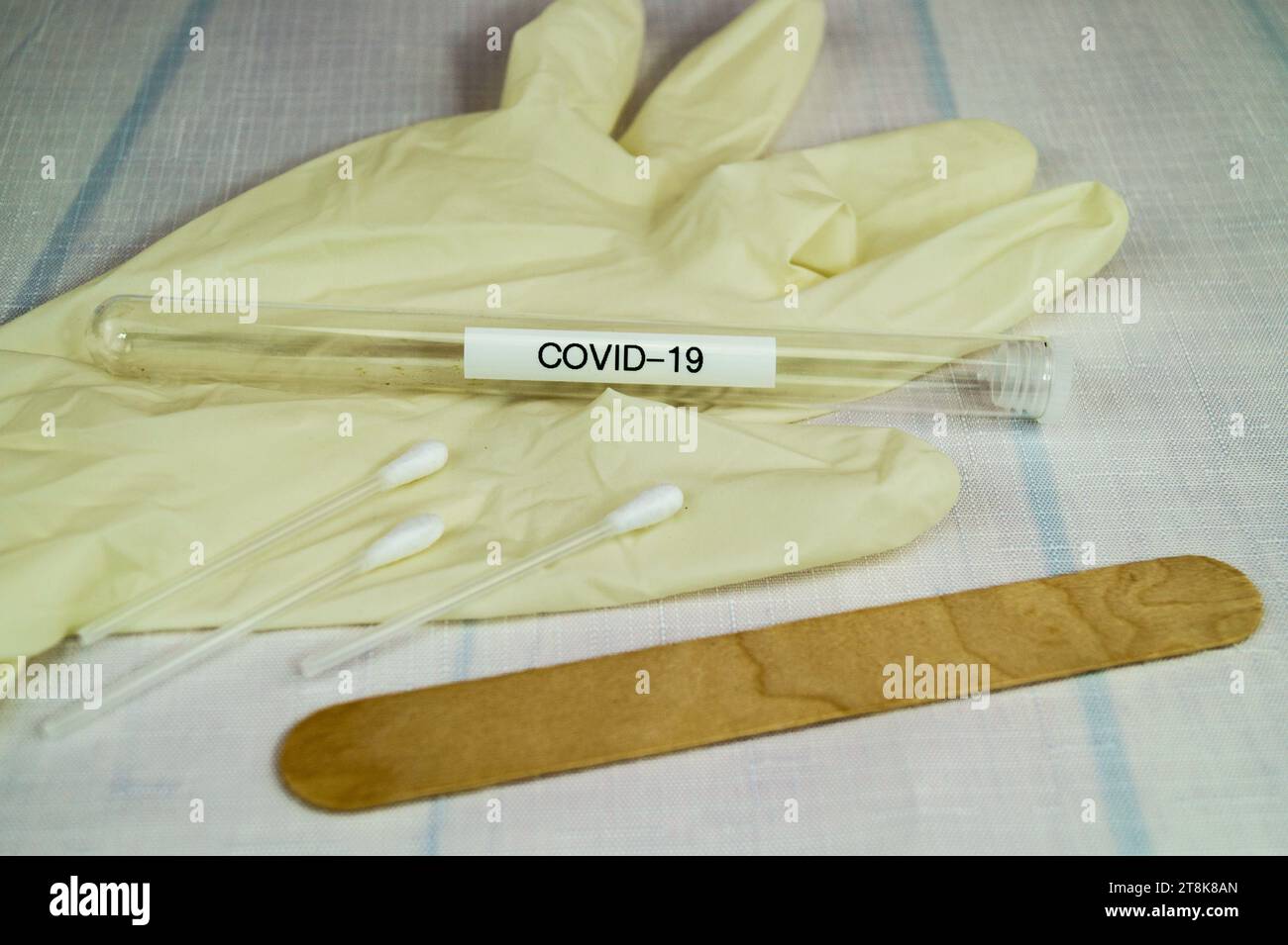 Corona-Testschlauch, Latexhandschuh, Wattestäbchen und Spachtel Stockfoto