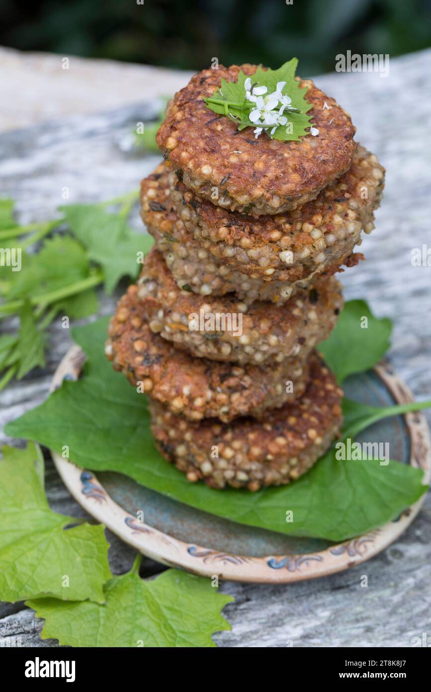 selbstgemachte Kräuterpasteten mit wildem Knoblauch auf einem Teller, dekoriert mit Gänseblümchen Stockfoto