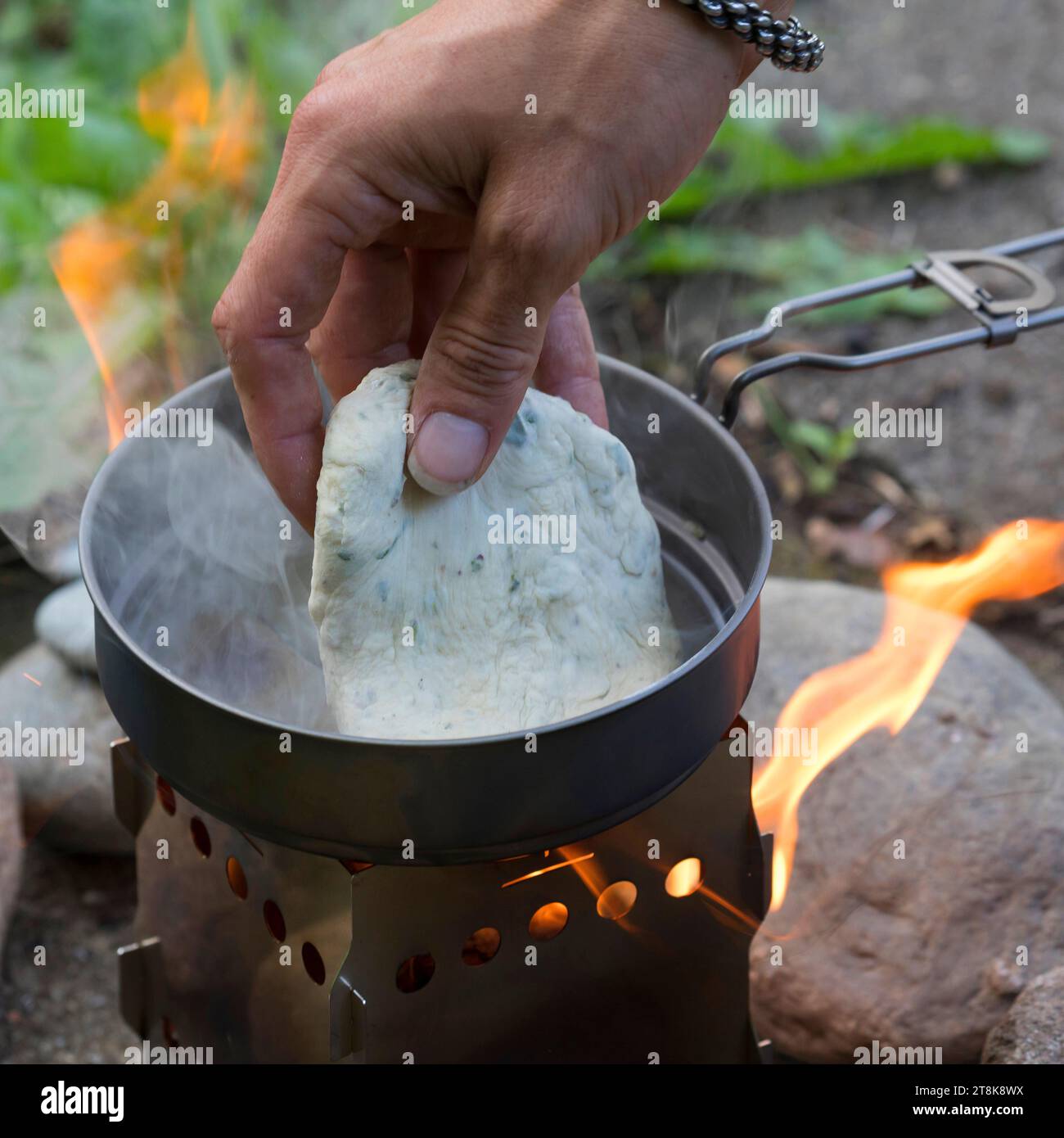 Bannockherstellung, wird auf offenem Feuer gebacken, Brotteig wird gebildet und in einer Pfanne auf einem Campingkocher gebacken, Serienbild 5/5 Stockfoto