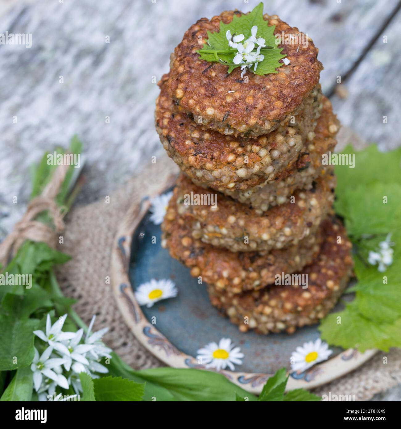 selbstgemachte Kräuterpasteten mit wildem Knoblauch auf einem Teller, dekoriert mit Gänseblümchen Stockfoto