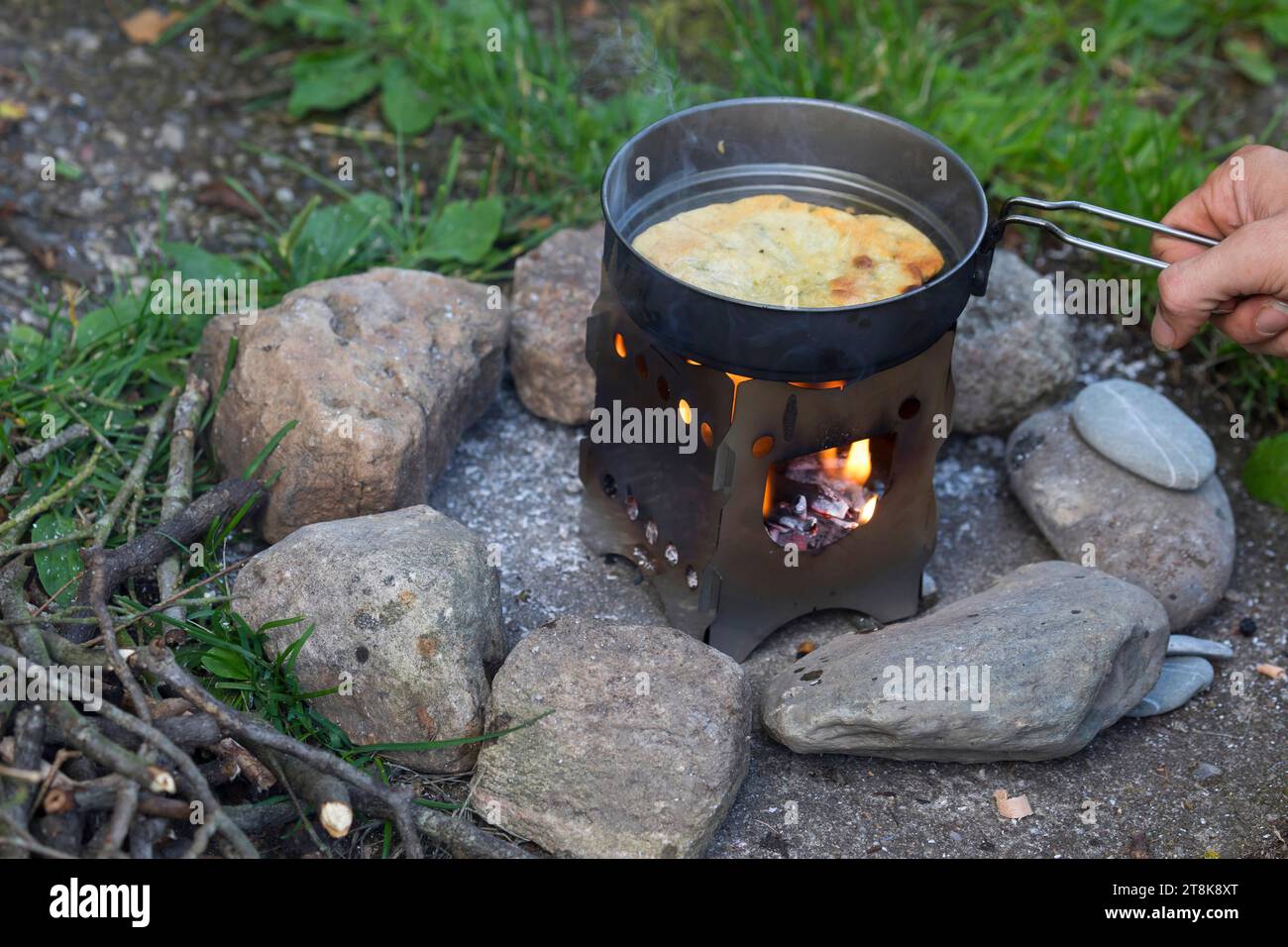 Bannockherstellung, wird auf offenem Feuer gebacken, Brotteig wird gebildet und in einer Pfanne auf einem Campingkocher gebacken, Serienbild 5/5 Stockfoto