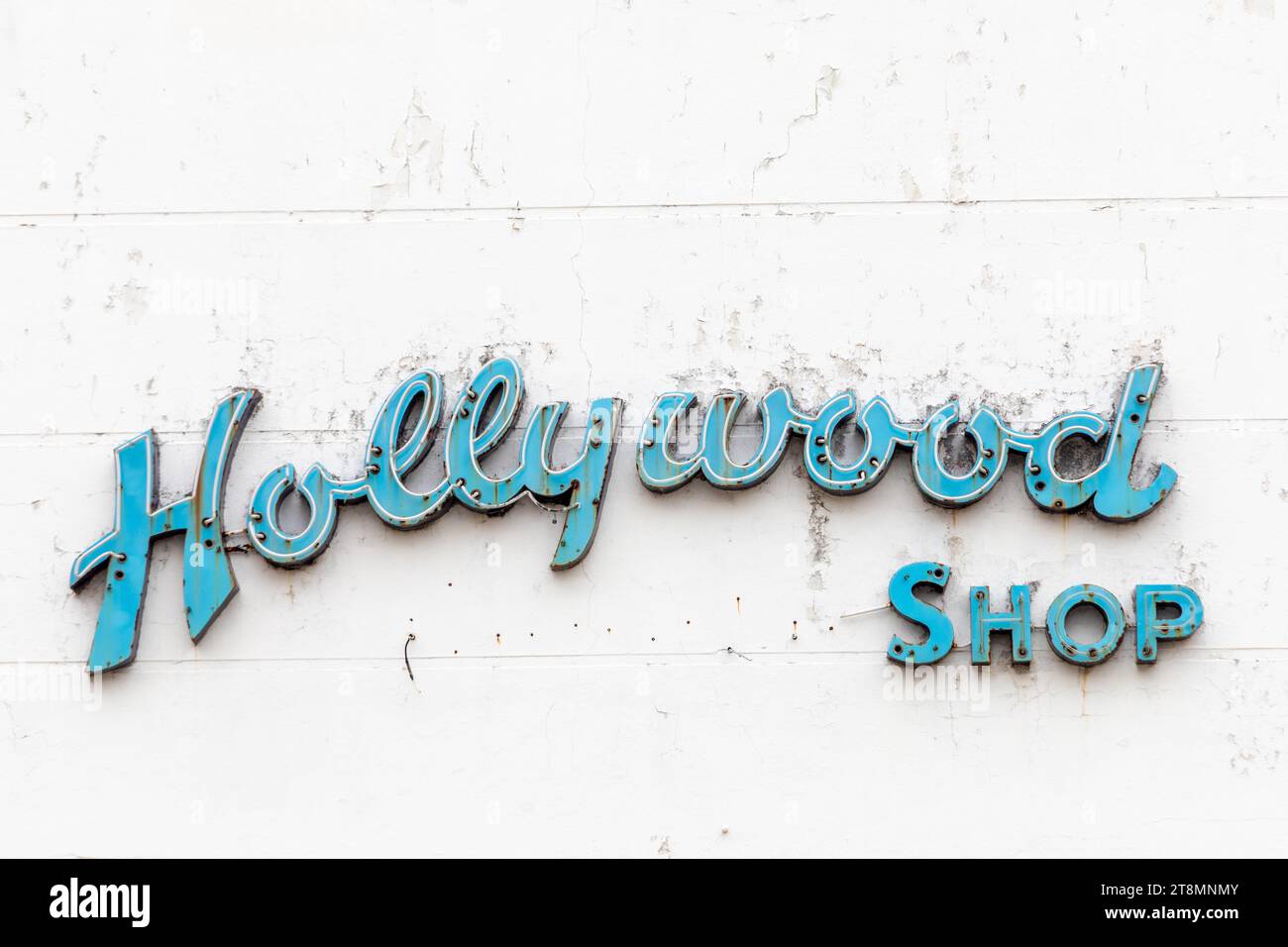 Galveston, USA - 10. November 2023: Verrottete und schmutzige Neonwerbung für Hollywood-Shop in einem alten Backsteinhaus aus dem 19. Jahrhundert in Galveston, Stockfoto