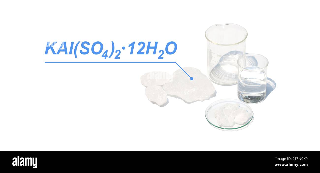 Alumkristall mit chemischer Formel, chemischer Zutat auf weißem Labortisch. Stockfoto