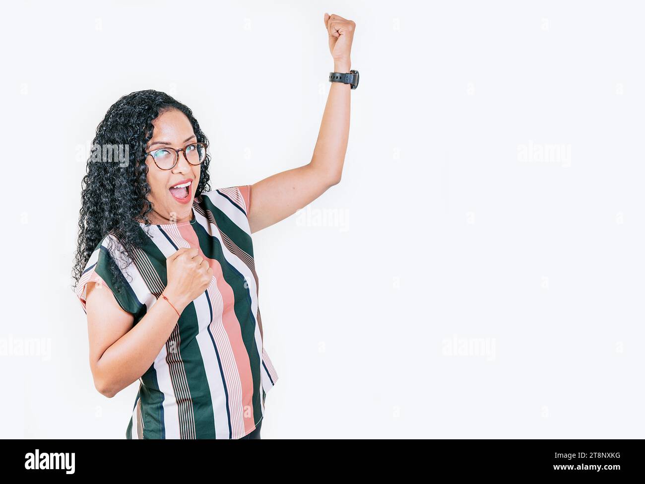 Aufgeregt Afro-Mädchen, das die Arme erhebt, um den Sieg zu feiern. Glückliche junge Frau, die die Arme in Siegesgesgestik hebt, isoliert. Menschen gewinnen, die Triumph feiern Stockfoto