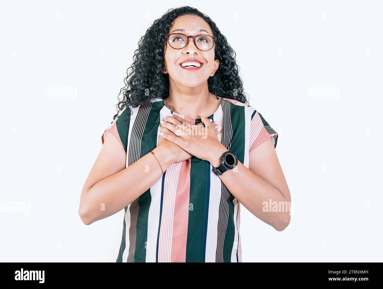 Dankbares entspanntes Afro-Mädchen mit Händen auf der Brust. Konzept dankbarer Menschen. Positive Afro-Frau mit einem charmanten, aufrichtigen Lächeln und dankbar Stockfoto