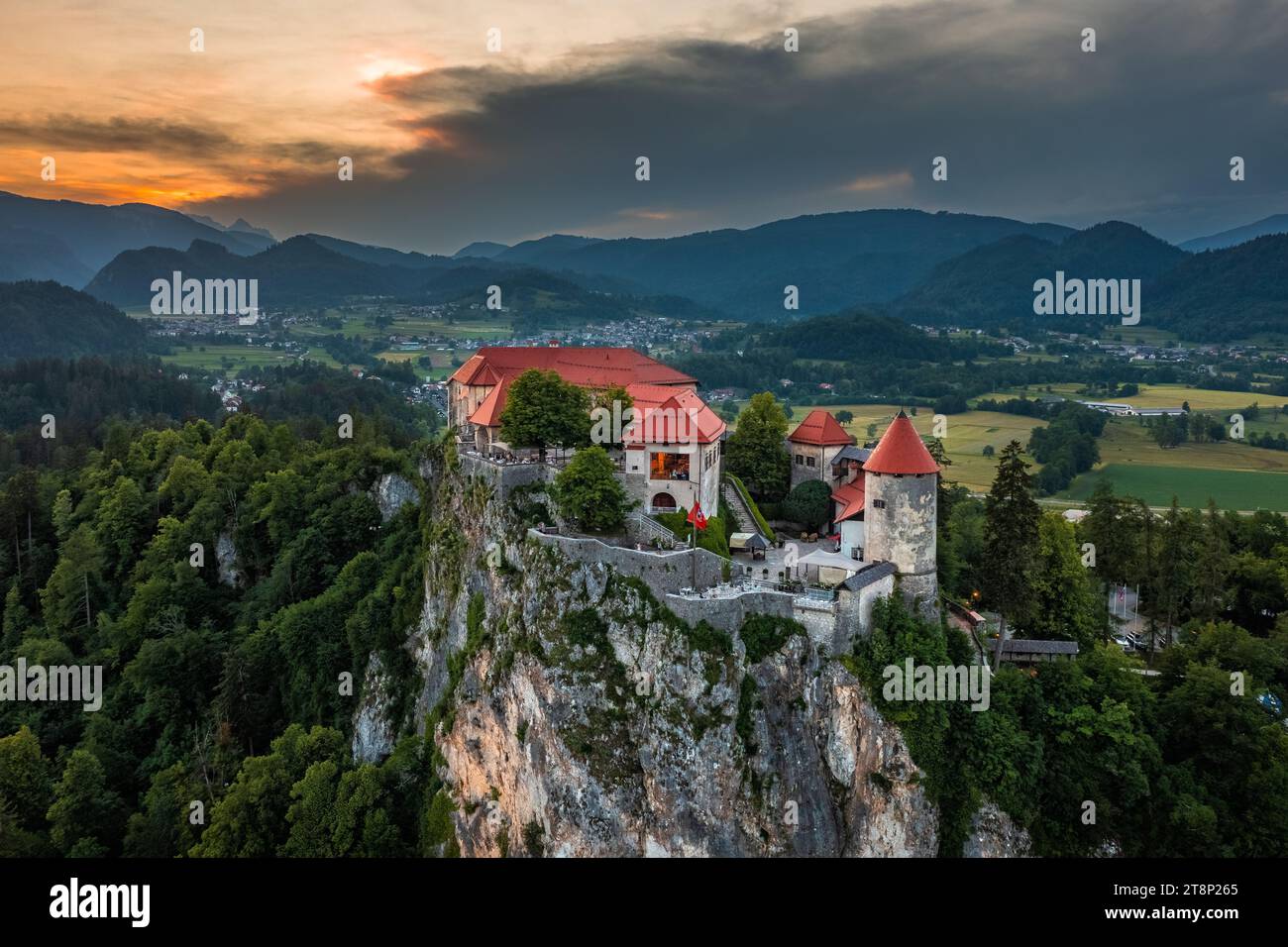 Bled, Slowenien - aus der Vogelperspektive auf das wunderschöne Schloss Bled (Blejski Grad) mit dramatischem goldenem Sonnenuntergang über den Julischen Alpen im Hintergrund Stockfoto