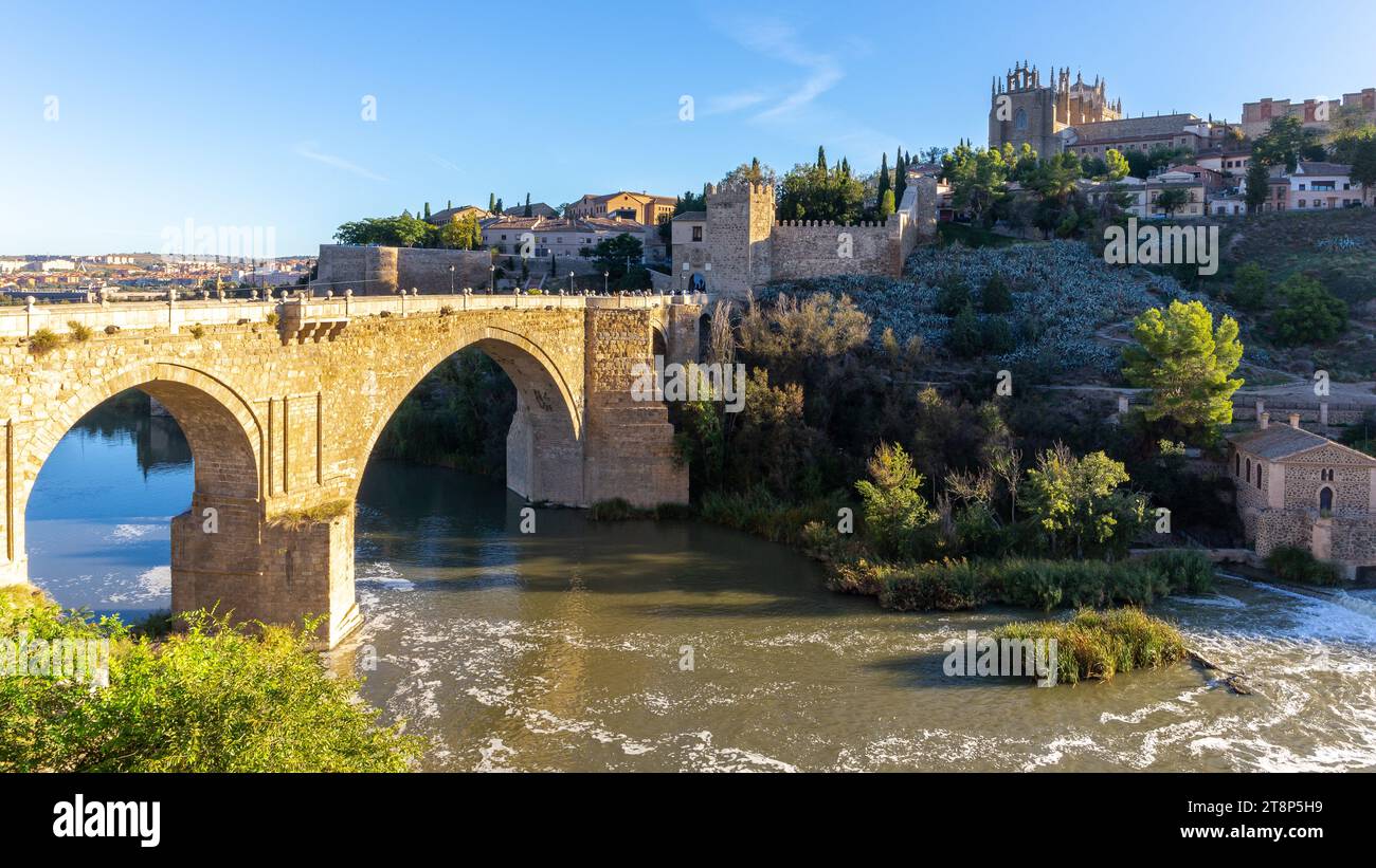 Die San Martin-Brücke, mittelalterliche Brücke über den Tejo mit Türmen mit Zinnen und Kloster San Juan de los Reyes im Hintergrund, Toledo, Stockfoto
