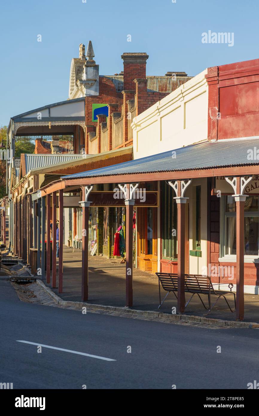 Eine historische Straßenlandschaft gesäumt von Veranden in der späten Nachmittagssonne in Maldon im Zentrum von Victoria, Australien. Stockfoto