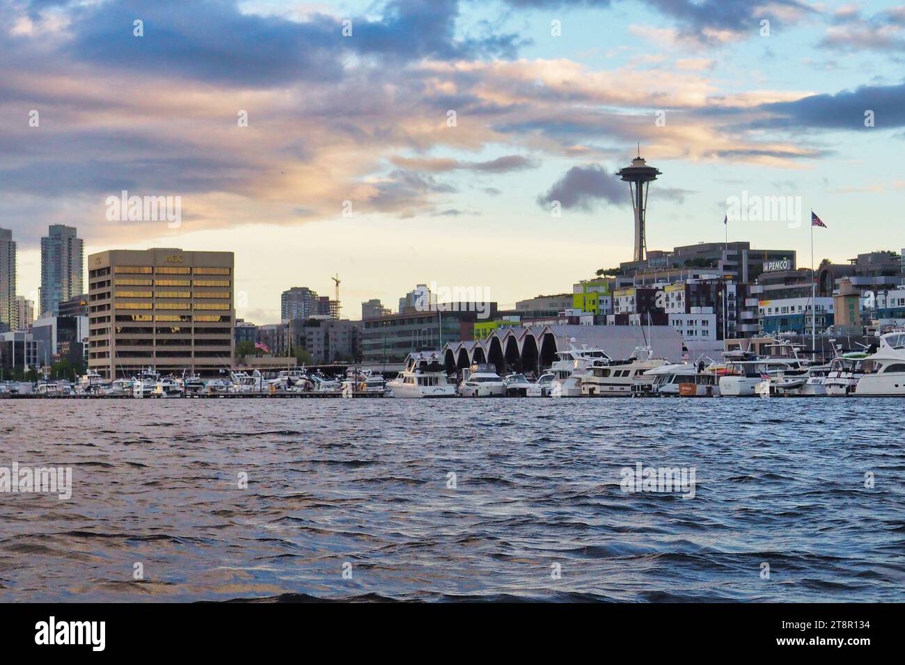 Ein Blick auf Seattles Space Needle und South Lake Union Nachbarschaft vom Wasser am Lake Union. Innenstadt mit dramatischem Himmel und Wolken bei Sonnenuntergang. Stockfoto