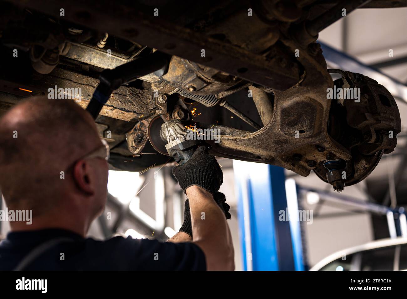 Mechanische Reparatur der Fahrzeugaufhängung mit Schneidwerkzeug bei geringer Feldtiefe Stockfoto