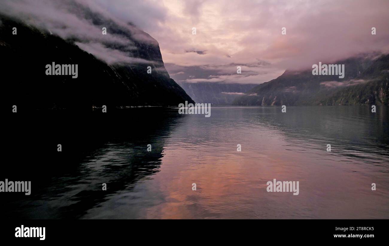 Sonnenaufgang. Milford Sound NZ, Milford Sound (Māori: Piopiotahi) ist ein Fjord im Südwesten der Südinsel Neuseelands, im Fiordland-Nationalpark, im Piopiotahi (Milford Sound) Marine Reserve und im Te Wahipounamu-Weltkulturerbe. Es wurde in einer internationalen Umfrage (Travelers' Choice Destinations Awards 2008 von TripAdvisor) zum weltweit besten Reiseziel gewählt und gilt als Neuseelands berühmtestes Reiseziel. Rudyard Kipling nannte es zuvor das achte Weltwunder Stockfoto