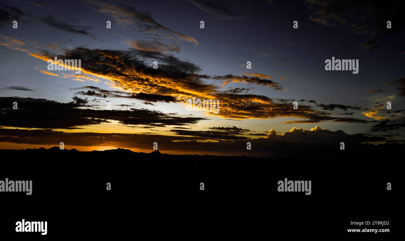 Sonnenuntergang in der Wüste mit satten Farben und blaustem Himmel, der von Dämmerung in Nacht übergeht. Stockfoto