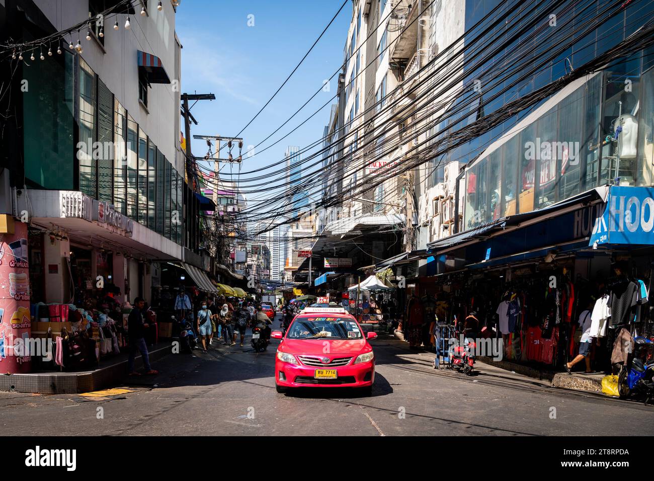 Ein Taxi fährt durch die geschäftigen Straßen von Pratunam Market, Bangkok, Thailand. Stockfoto
