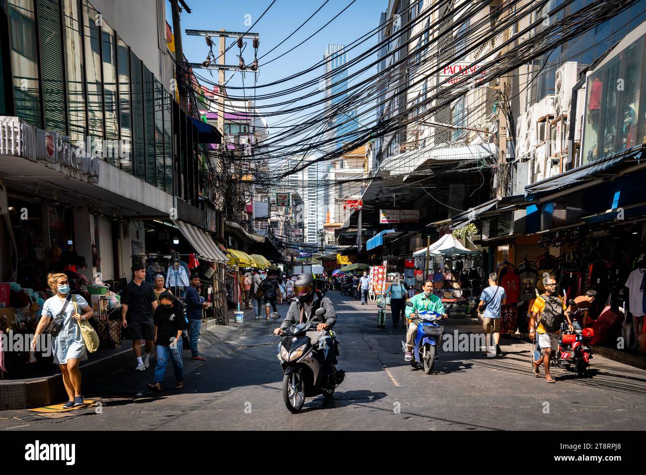 Ein Motorrad fährt durch die geschäftigen Straßen von Pratunam Market, Bangkok, Thailand. Stockfoto