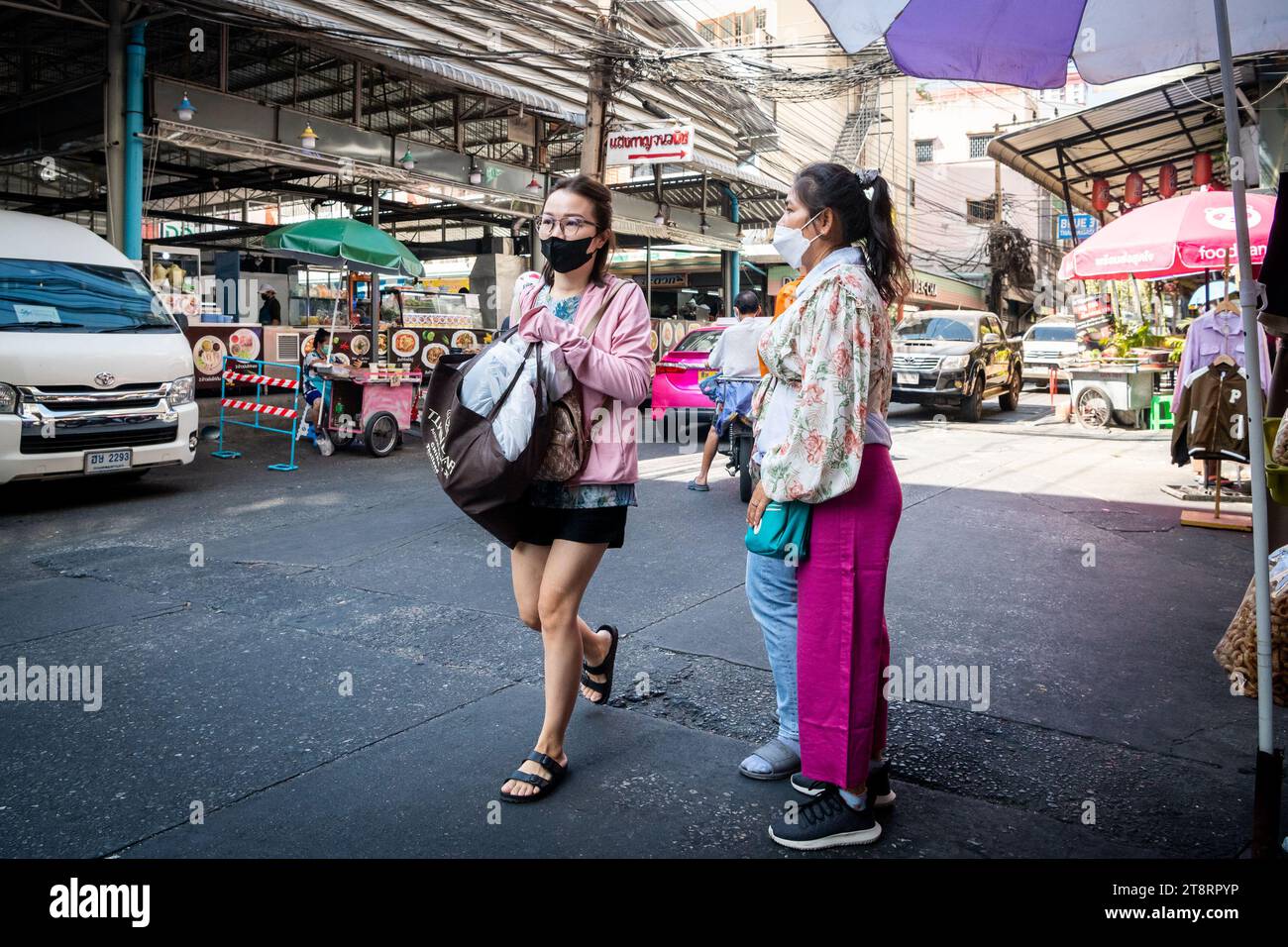 Eine junge Thailändin macht sich den Weg durch den Pratunam Markt, um ihr Einkaufen zu erledigen. Stockfoto