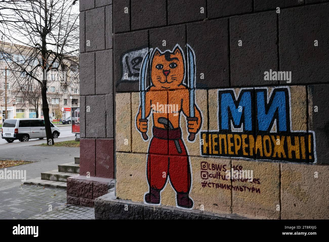 An der Wand eines Gebäudes in Zaporischzhia ist ein patriotisches Katzengraffiti (geschrieben: „Wir sind unbesiegbar“), das vom LBWS CAT UKRAINE-Team hergestellt wurde. LBWS CAT UKRAINE ist ein Team von Künstlern aus Odesa City, die patriotische Straßenkunst mit verschiedenen Bildern von Katzen in Kriegszeiten kreieren. Die Künstler sagen, dass sie Katzen ausgewählt haben, weil dies eines der inoffiziellen Symbole ihrer Heimatstadt Odesa ist. Ihor Matroskyn und Andrii Bilyi kommen beide aus Odesa und sind Teil der LBWS CAT UKRAINE, die derzeit aus fünf Personen besteht, von denen die meisten lieber anonym bleiben. Die Künstler verwenden ihre eigenen Mittel Stockfoto