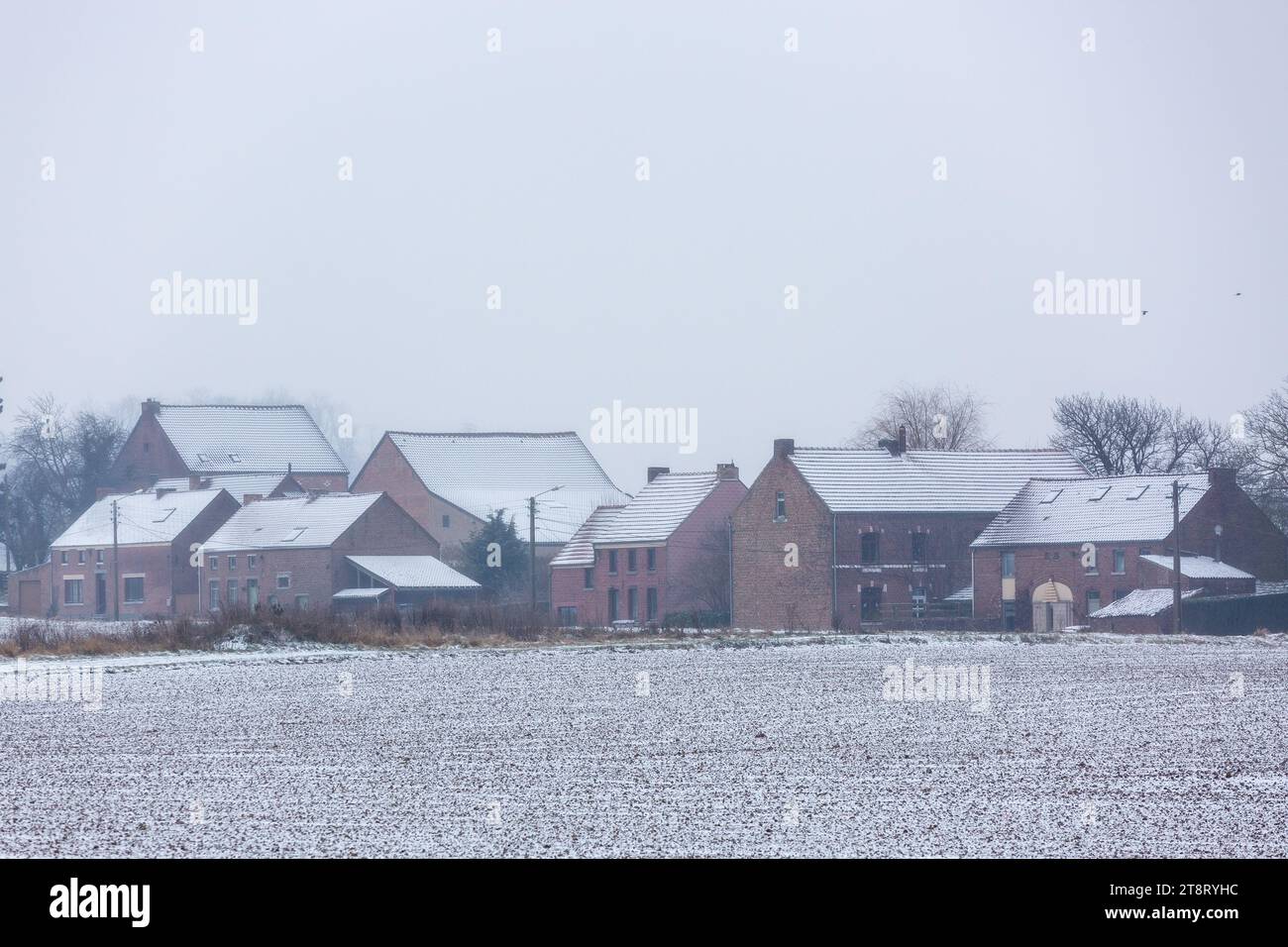 Eine Gruppe von Häusern drängte sich an einem grauen Wintertag unter Kälte und Schnee zusammen. Stockfoto