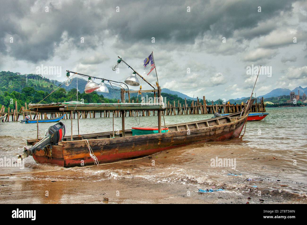 Das Boot Langkawai, Black Sand Beach Langkawi, das vier Kilometer südwestlich von Tanjung Rhu Beach liegt, bietet unvergessliche Fotogelegenheiten und einen friedlichen Rückzugsort von den oft überfüllten Inseln. Eine 20-minütige Fahrt von der Langkawi Cable Car entfernt, ist ein beliebter Treffpunkt bei Einheimischen, besonders an Wochenenden und Feiertagen Stockfoto