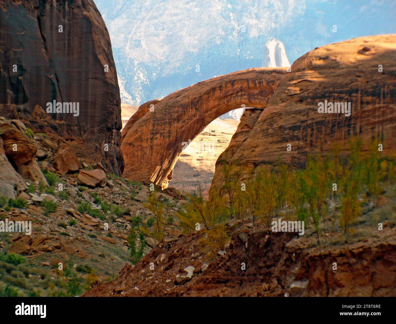 Regenbogenbrücke. National Monument, Rainbow Bridge, am Rande des Lake Powell, ist mit 290 Fuß/88 Meter Höhe und 270 Fuß/83 Meter Durchmesser die größte natürliche Brücke der Welt. Die Rainbow Bridge wird von der Navajo-Kultur als ein Symbol der Gottheiten angesehen, die für die Entstehung von Wolken, Regenbögen und Regen verantwortlich sind - das Wesen des Lebens in der Wüste Stockfoto