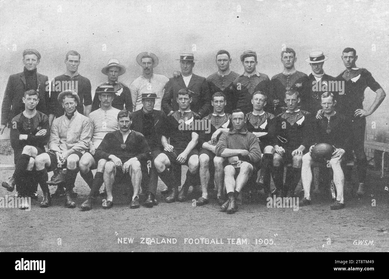 Postkarte. Die neuseeländische Fußballmannschaft, 1905 / G.W.S.M. 1905?, zeigt ein Gruppenfoto von 21 Männern, die meisten davon in Rugbykleidung, mit silbernem Farnlogo. Der Verso listet die Spiele auf, die vom 16. September bis zum 30. Dezember 1905 in Großbritannien gespielt wurden. Alter, Gewicht und Körpergröße aller Spieler werden angegeben Stockfoto