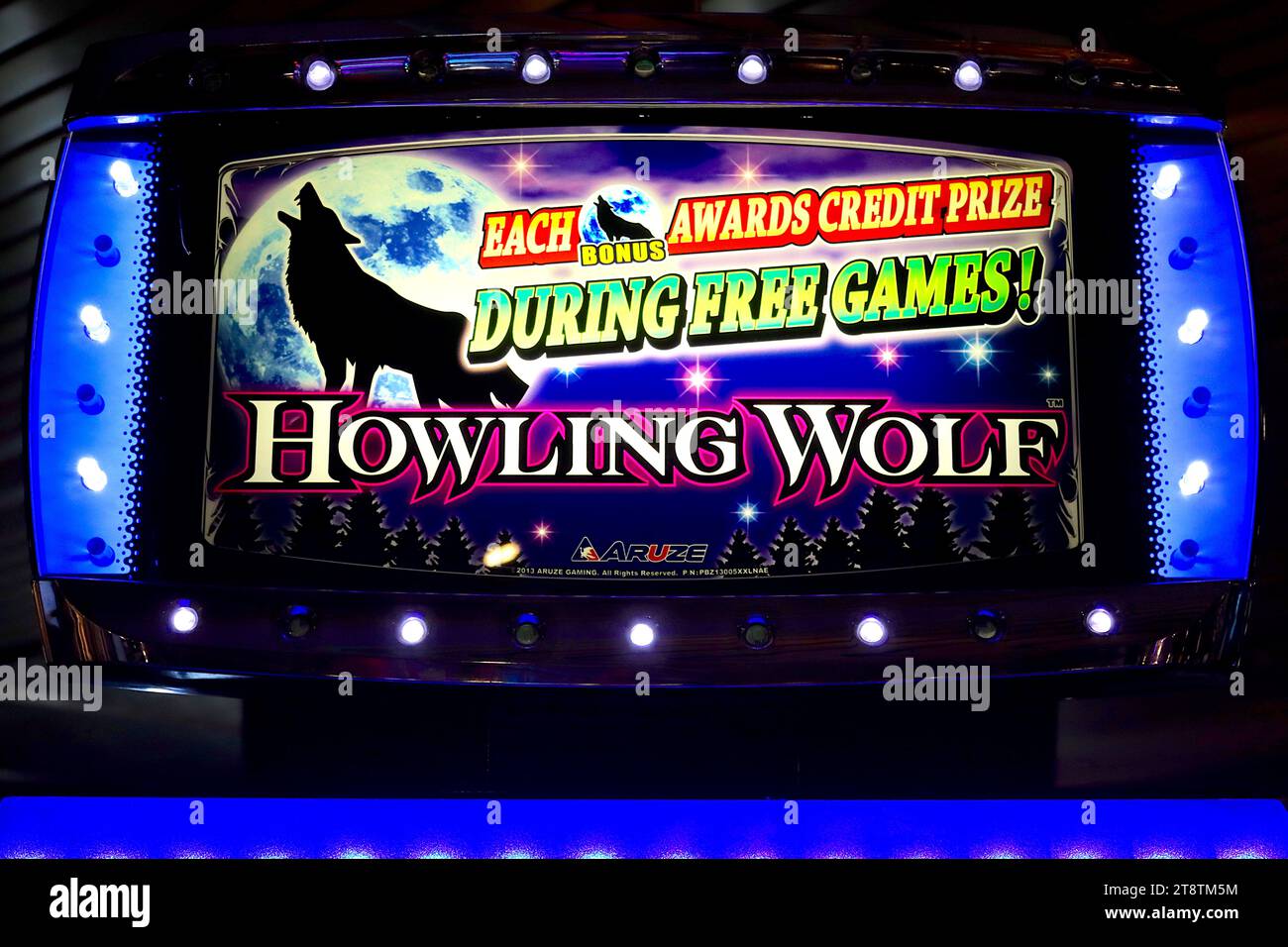 Detailaufnahme einer beleuchteten Titelzeile der Slots Heulling Wolf auf einem der beliebten Spielautomaten in einem Casino-Bereich an Bord. Stockfoto