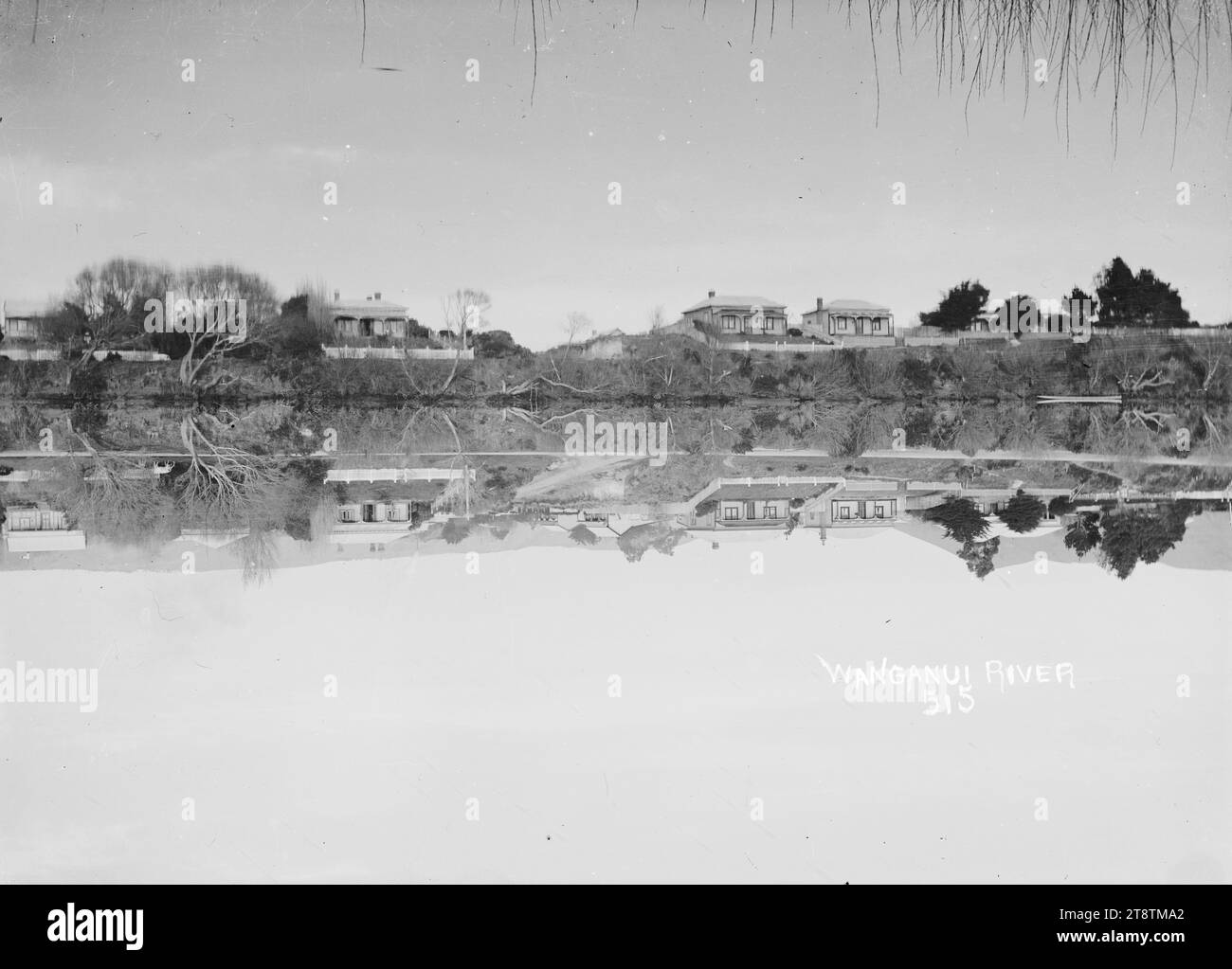 Blick auf den Whanganui River, Blick auf den Whanganui River, mit einer Reihe von einstöckigen Häusern auf der anderen Seite. Das Foto zeigt ein fast perfektes Spiegelbild mit Reflexion im Wasser Stockfoto