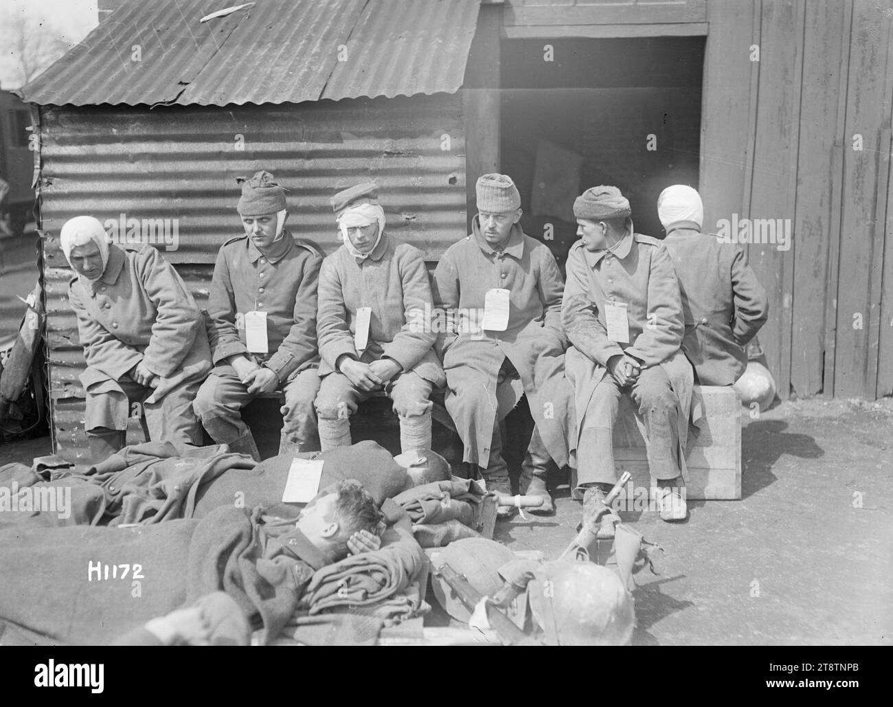 Verwundete deutsche Gefangene in Louvencourt, Frankreich, während des Ersten Weltkriegs, verwundete deutsche Gefangene in einer neuseeländischen Vernichtungsstation in Louvencourt Mit ihren Wunden verbündet sitzen sie und warten auf die Evakuierung. Zwei liegen auf Bahren. Foto vom 22. April 1918 Stockfoto
