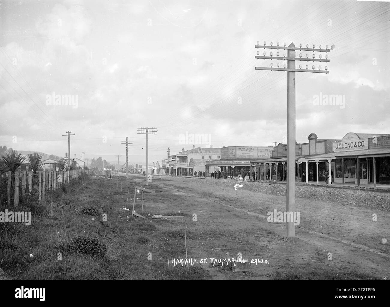Hakiaha Street, Taumarunui, Hakiaha Street, Taumarunui, ca. 1910er Jahre mit den Geschäftsräumen von J E Long & Co, Kaufleuten, Mitte rechts und der Taumarunui Bahnhof sichtbar hinter einem Zaunzentrum links Stockfoto