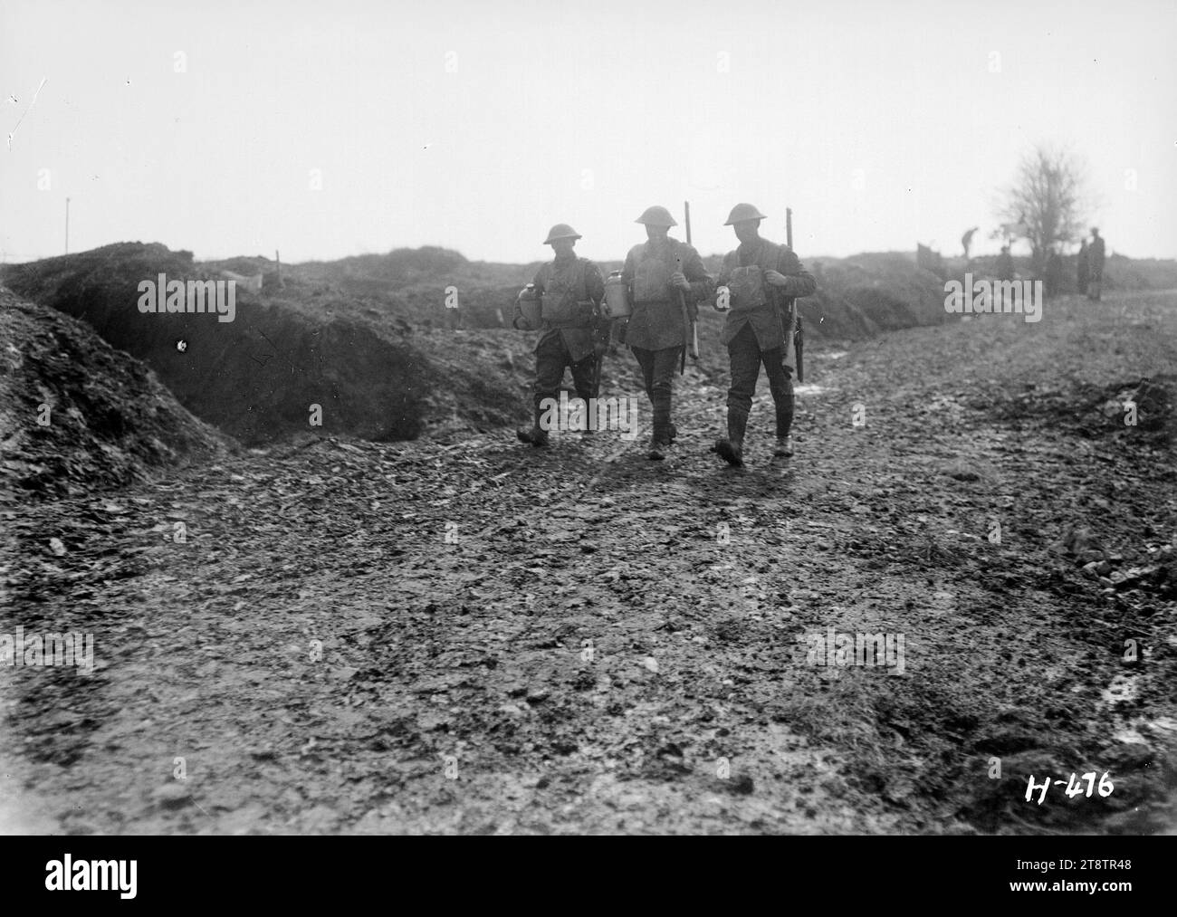 Soldaten bringen die Rum-Ration an ihre Kameraden an der Front, Frankreich, und drei neuseeländische Soldaten, die eine schlammige Straße hinunterlaufen und Keramikfahnen mit Rum an die Truppen an der Front verteilen. Foto: La Signy Farm im April 1918 Stockfoto