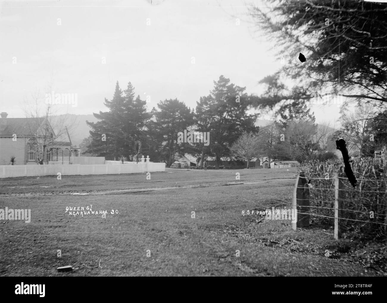 Queen Street, Ngaruawahia, Neuseeland, 1910 - Foto von Robert Stanley Fleming, Blick auf die Great South Road, die Hauptstraße durch Ngaruawahia, Neuseeland mit der Eisenbahnlinie auf der rechten Seite und eine Reihe von Geschäften auf der linken Straßenseite. Foto von R.S.F. (wahrscheinlich Robert Stanley Fleming, Lagerhalter in Ngaruawahia, Neuseeland) Stockfoto