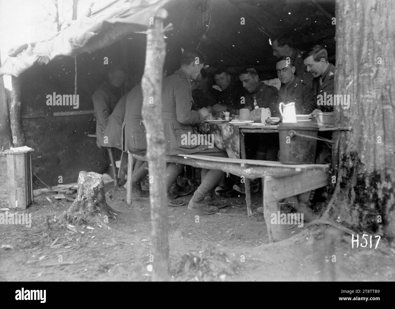 Ein Offiziersschlaf in den Transportlinien, Louvencourt, neuseeländische Offiziere sitzen an einem rauen Tisch und Bänke unter Leinwand im Offiziersschlaf in einem Wald in der Nähe von Louvencourt, Frankreich. Foto vom 22. April 1918 Stockfoto