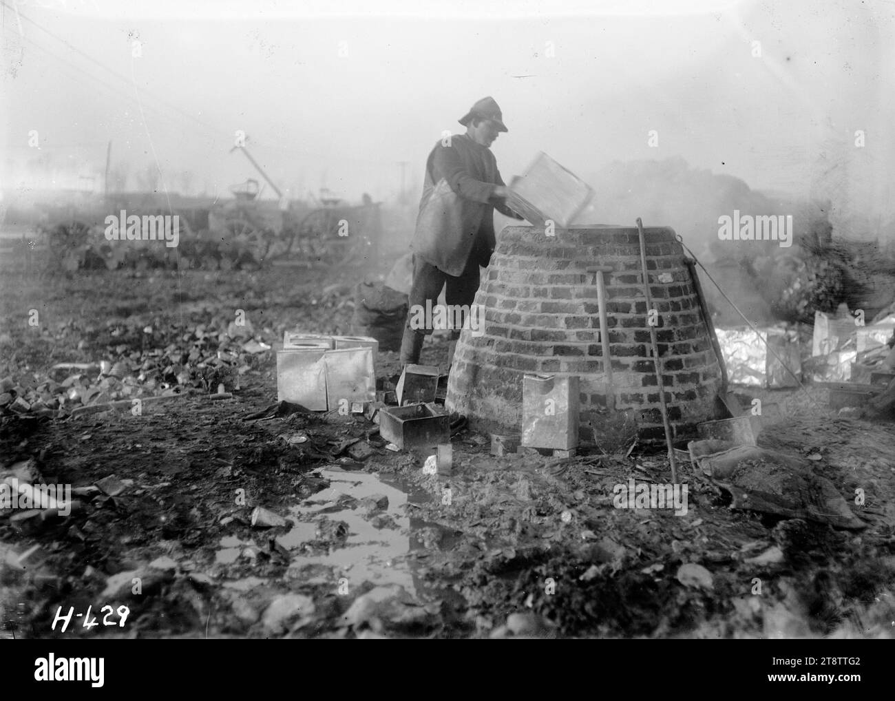 Recycling von Lot an der Westfront, Dem Ersten Weltkrieg, Einem Abfall- und Bergungsgebiet aus dem Ersten Weltkrieg in Cape Belge, Ypern, wo ein Mann Dosen und Dosen für ihr Lot und andere wiederverwendbare Metalle sammelt. Foto vom 5. Februar 1918 Stockfoto