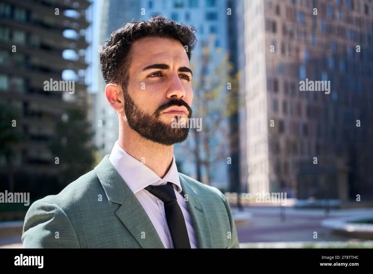 Reifer, erfolgreicher Geschäftsmann, ernsthaft selbstbewusst, der sich außerhalb des Büros in einem Finanzzentrum umsieht Stockfoto