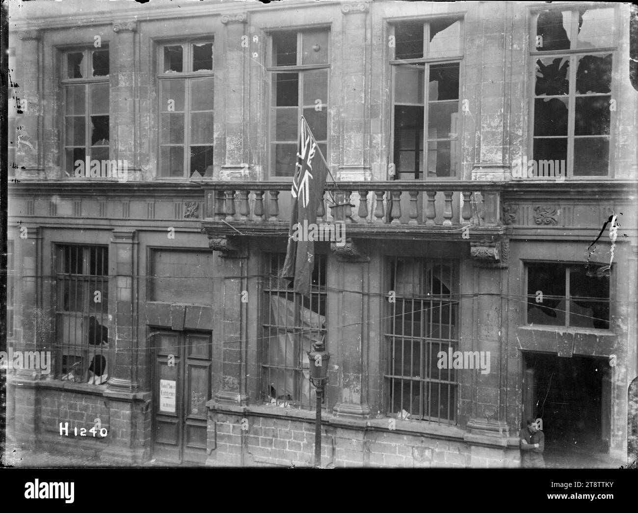 Die neuseeländische Flagge wird Le Quesnoy präsentiert, die neuseeländische Flagge wird der Stadt Le Quesnoy auf dem Rathaus präsentiert, das teilweise durch Bombenangriffe zerstört wurde. Foto, aufgenommen um Ende November 1918 Stockfoto
