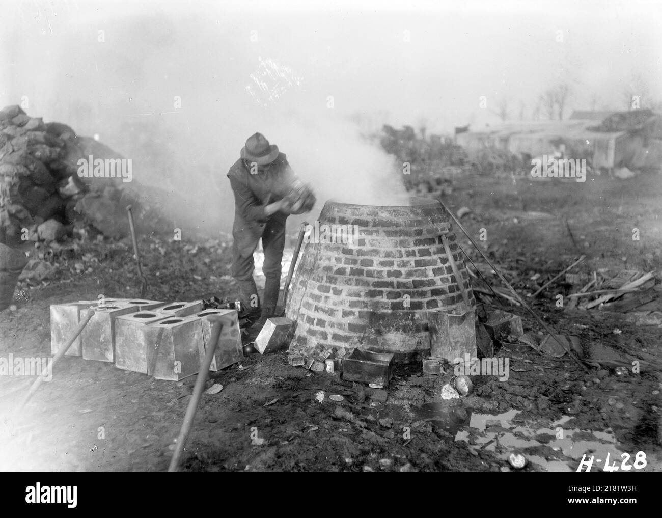 Recycling von Lot an der Westfront, Dem Ersten Weltkrieg, Einem Abfall- und Bergungsgebiet aus dem Ersten Weltkrieg in Cape Belge, Ypern, wo ein Mann Dosen und Dosen für ihr Lot und andere wiederverwendbare Metalle sammelt. Foto vom 5. Februar 1918 Stockfoto