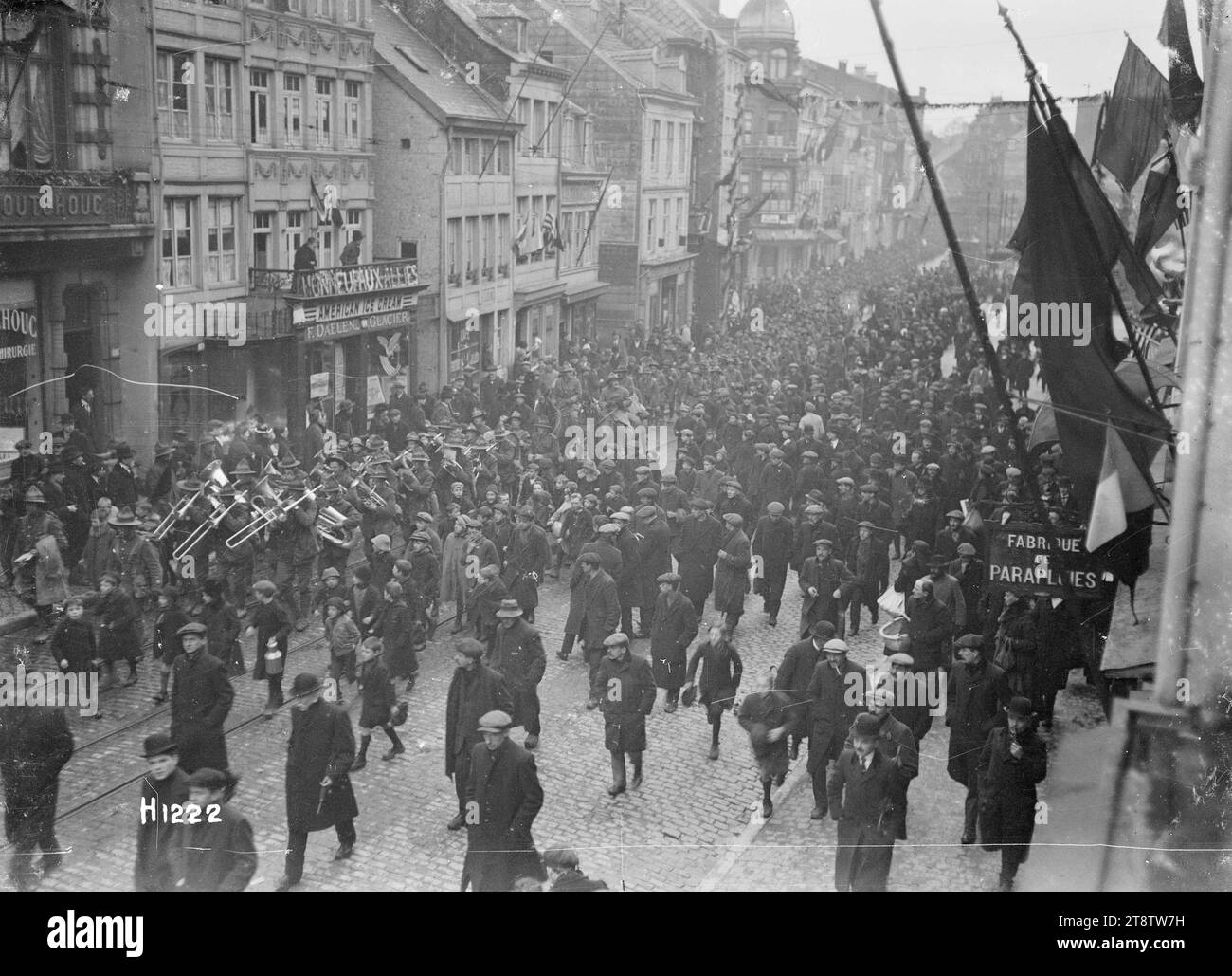 Nach dem Waffenstillstand führt eine Armee neuseeländische Truppen durch eine Stadt am Rhein, nach dem Waffenstillstand führt eine Armee eine lange Kolonne neuseeländischer Truppen entlang einer Kopfsteinpflasterstraße durch eine Stadt entlang des Rheins (genaue Position unbekannt) Eine Reihe von Flaggen fliegt von Gebäuden. Eine Menschenmenge Zivilisten füllt die Straße. Foto, aufgenommen Ende 1918 Stockfoto