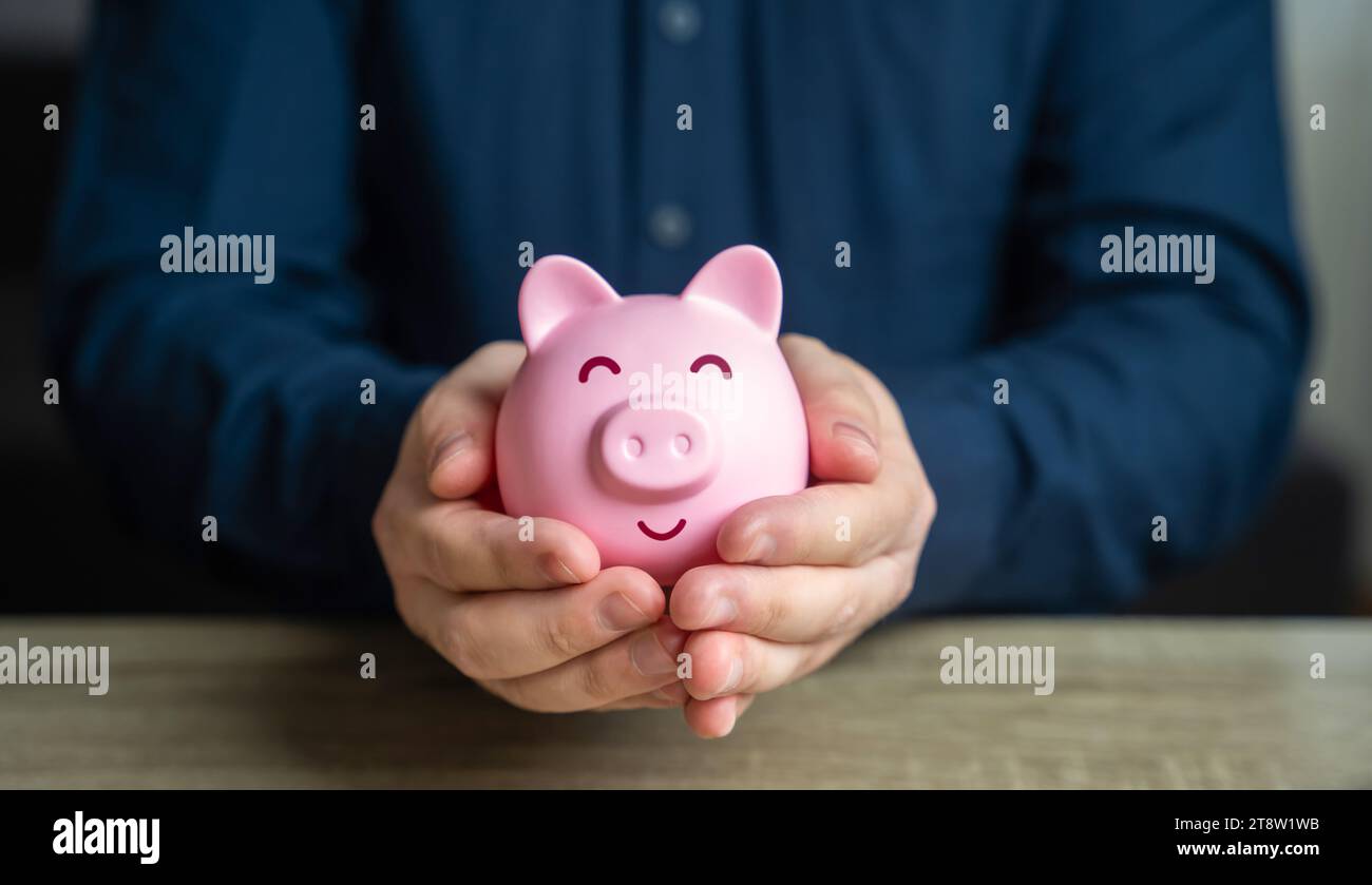 Ein Mann schützt seine Ersparnisse. Die Schweinebank ist in guten Händen. Spar- und Einlagengeschäft. Wohlstand und Wohlstand. Gesunde Wirtschaft. Erfolgreiche Investoren Stockfoto