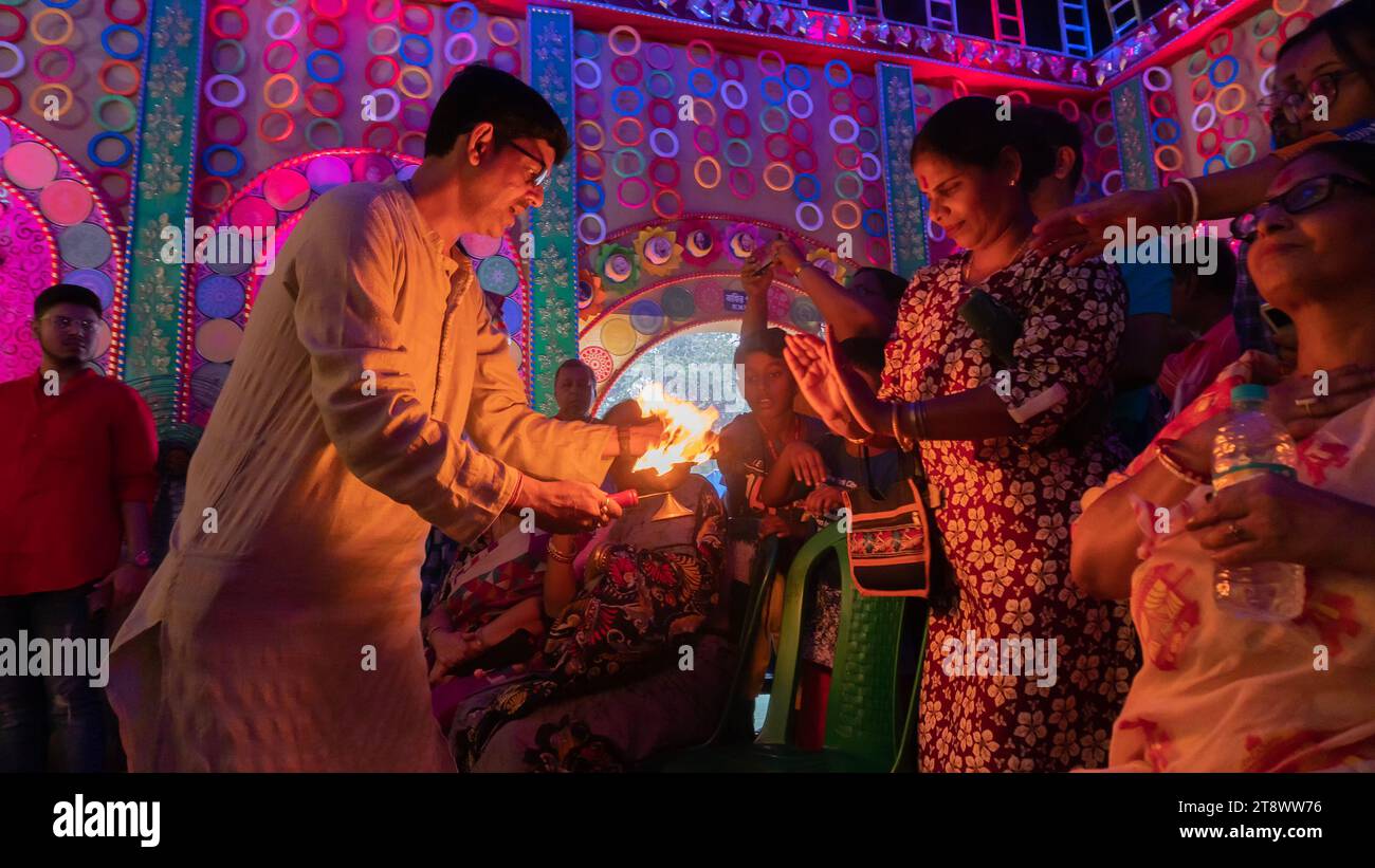 Howrah, Westbengalen, Indien - 5. Oktober 2022: Hindugeweihte teilen göttliche Segnungen der Göttin Durga aus der Flamme des Feuers des Heiligen Panapradip. Stockfoto