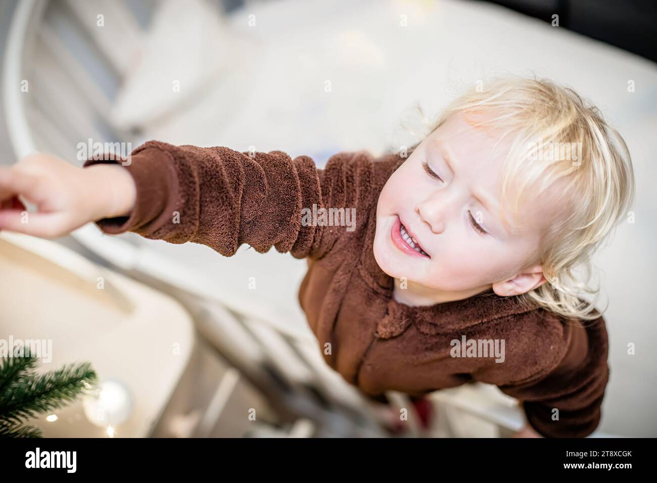 Porträt eines entzückenden kleinen Mädchens, das zu Hause mit weihnachtsdekoration spielt Stockfoto