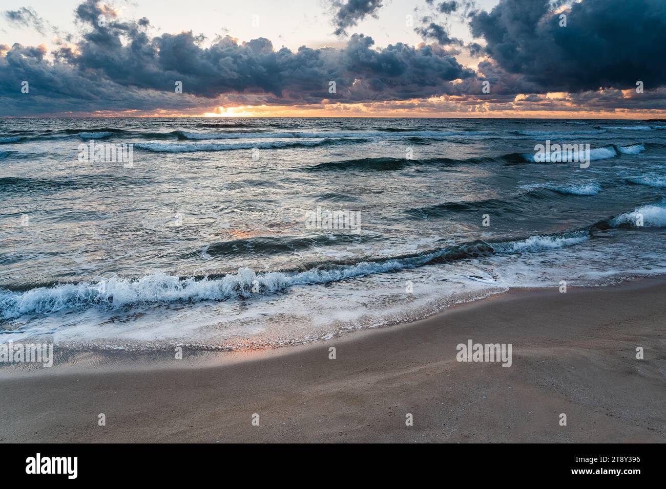 Wellen des schwarzen Meeres, Sandstrand und Sonne versteckt hinter dunklen Wolken Stockfoto